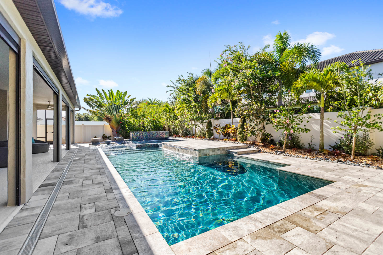pool with blue stonework and backyard trees